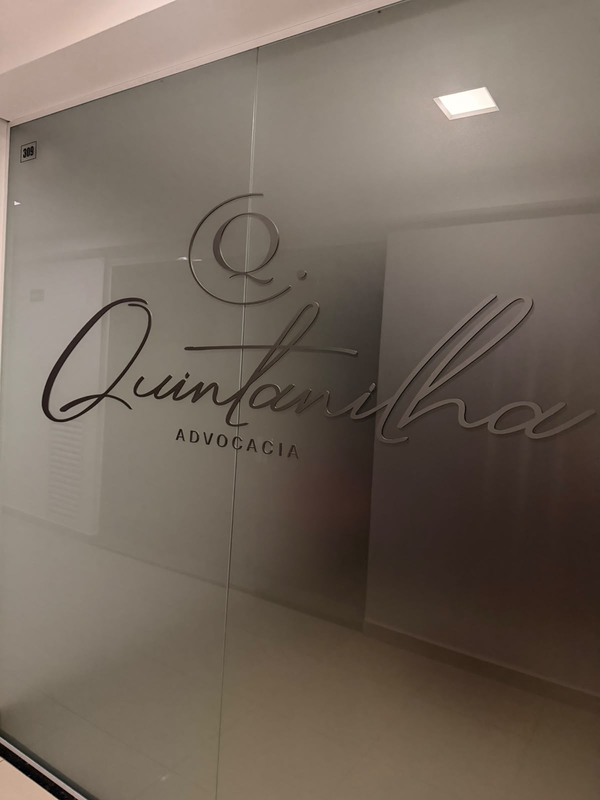 Logo da Quintanilha Advocacia em relevo na porta da sala 309